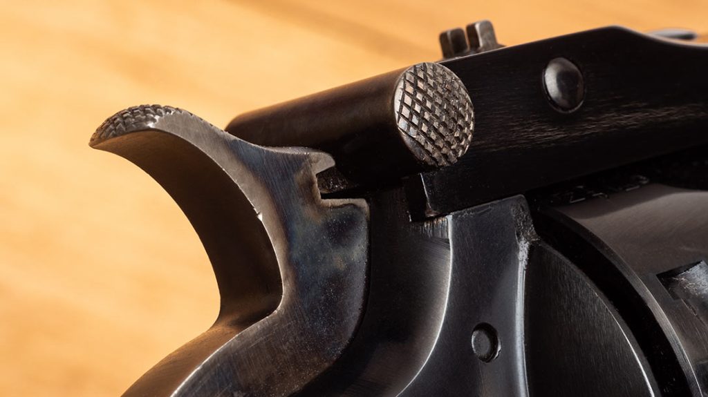 The original used a barrel-mounted latch, which was later changed to a frame-mounted latch on the Schofield version.