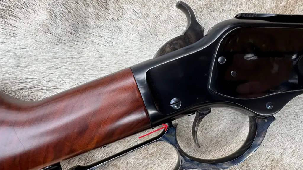 Two safeties are built into the Nueces ’73 Rifle; the hammer is in the safety notch, and the red arrow points to the button that must be pressed by the lever to fire.