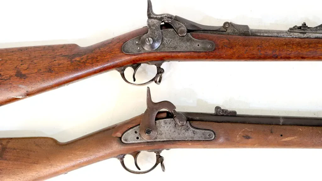 The Civil War-era Springfield rifle (bottom as represented by an M1864) served as the foundation for the Allin Trapdoor conversion.